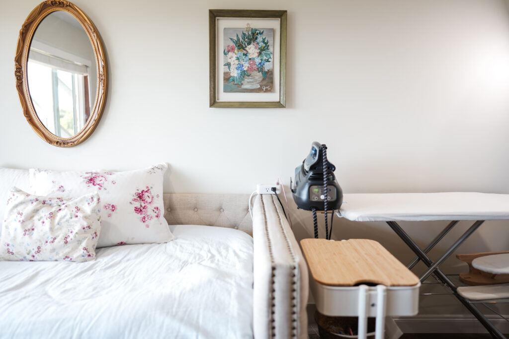 a day bed next to an iron and ironing board